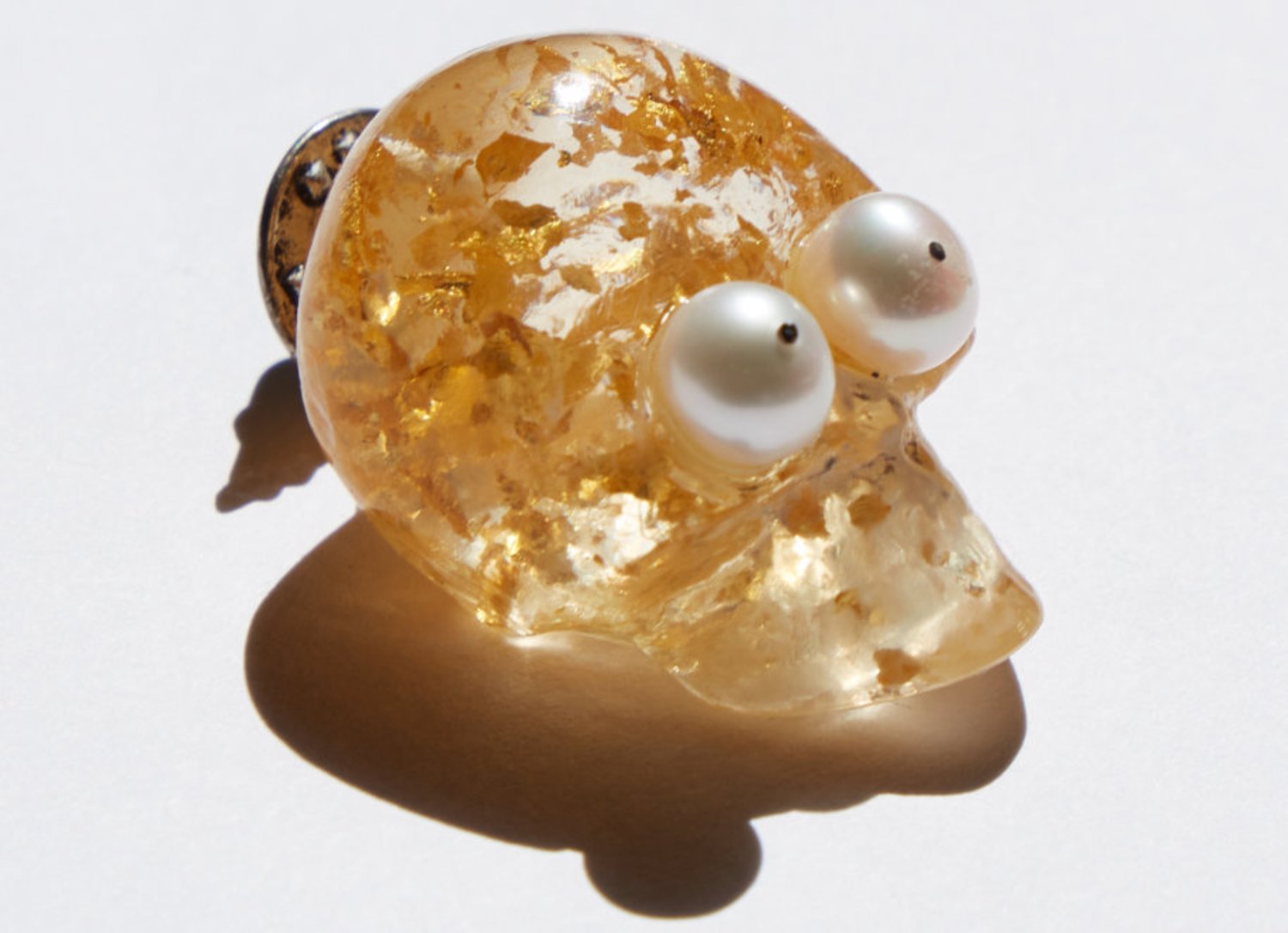 Till Death — a resin skull lit from within by gold leaf, with two pearls for eyes.